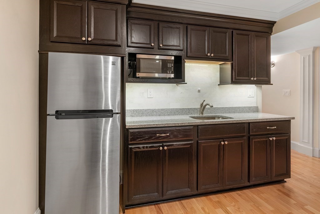 30 Pinecroft Road Weston, MA 02493 - Photo 34 of 38 a kitchen with granite countertop stainless steel appliances and wooden cabinets