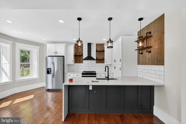 a kitchen with stainless steel appliances kitchen island granite countertop a refrigerator a sink and dishwasher