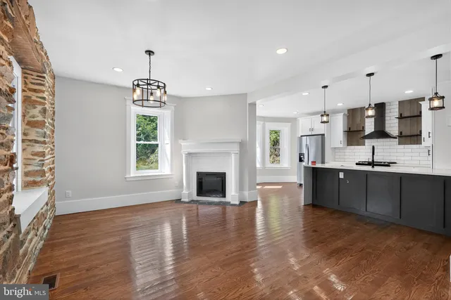 a large kitchen with cabinets wooden floor and a sink