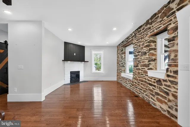 a view of a livingroom with wooden floor and a fireplace