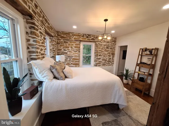 a bedroom with a large bed and a chandelier