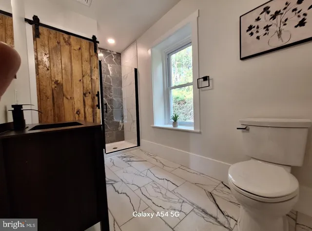 a bathroom with a granite countertop sink toilet and shower