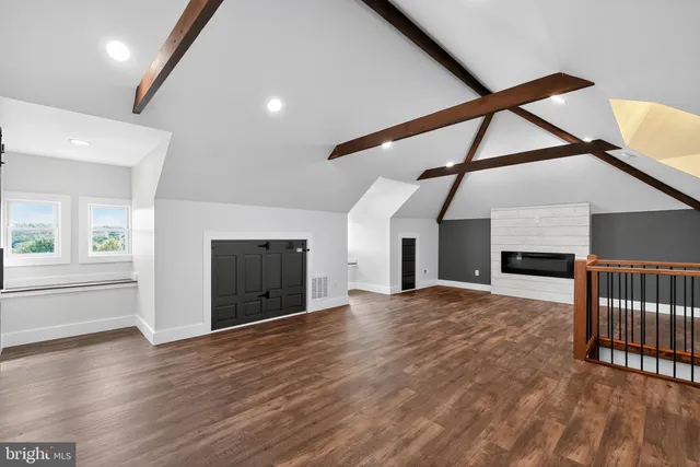 a view of empty room with wooden floor and fireplace