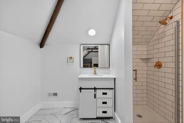 a bathroom with a sink a mirror and shower