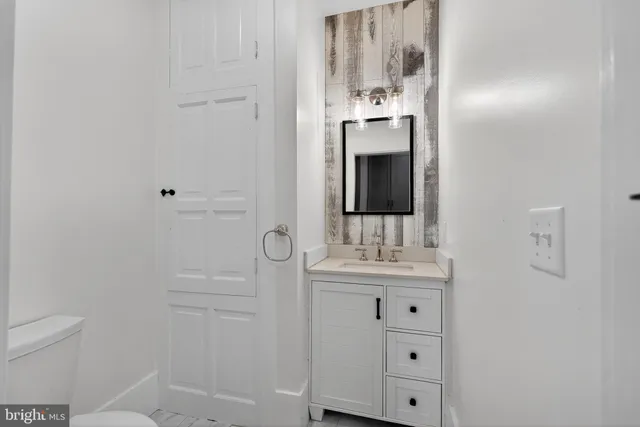 a bathroom with a sink a toilet and mirror