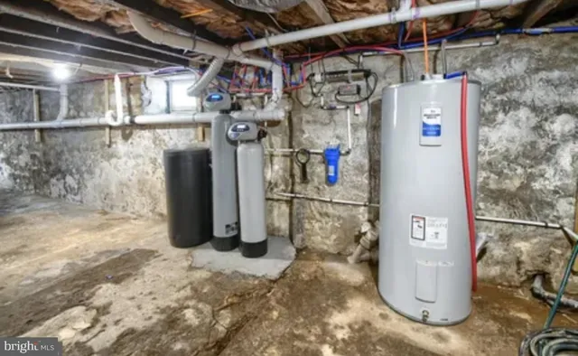 a utility room with water heater and refrigerator
