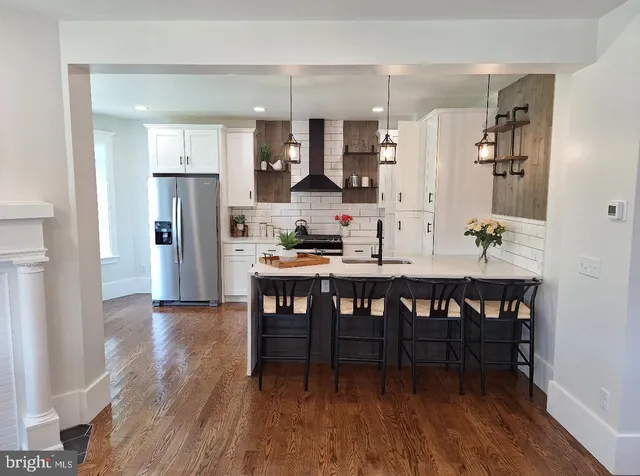 a dining room with stainless steel appliances kitchen island granite countertop furniture and wooden floor