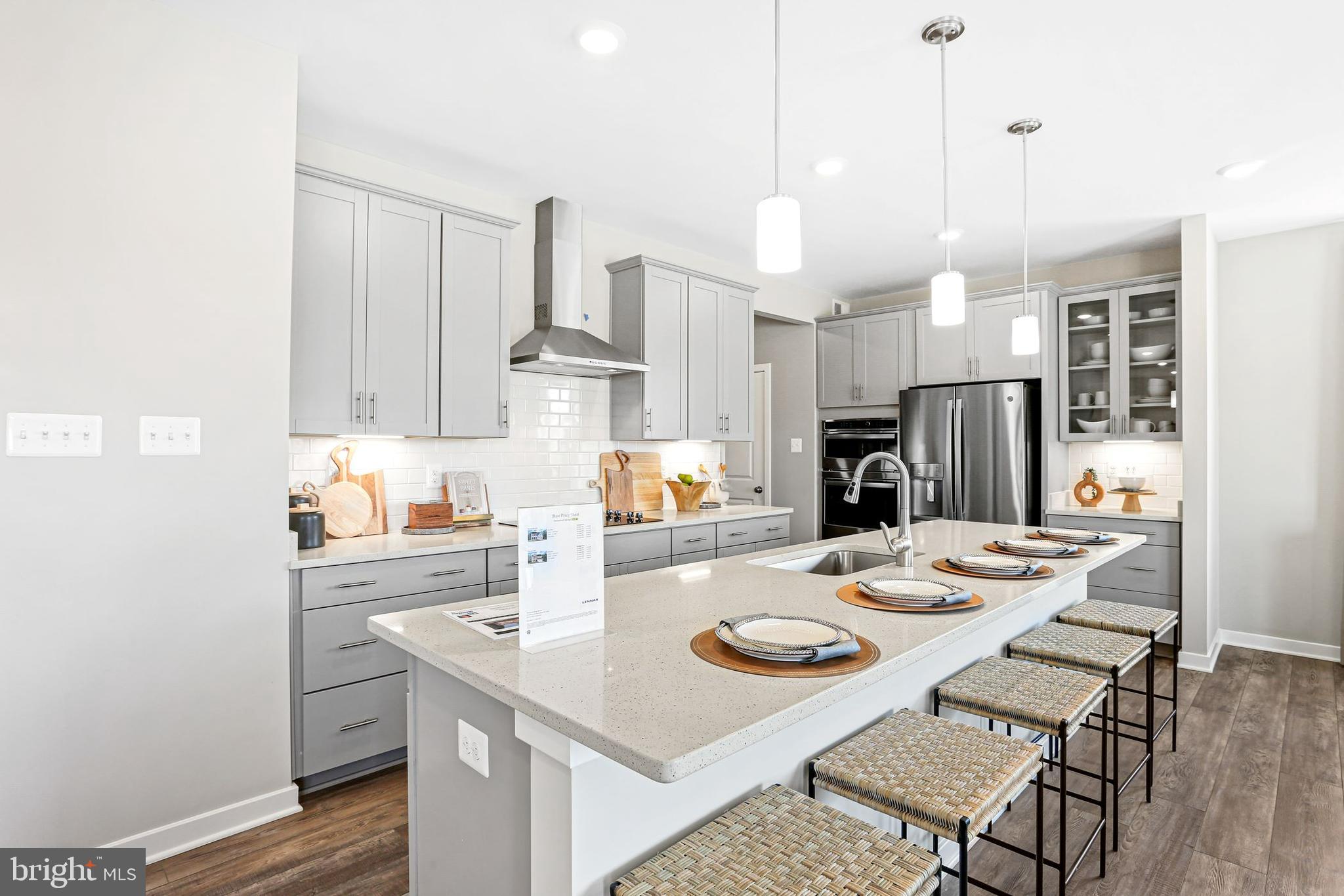 Shenandoah Springs Shenandoah Springs, Unit BRIARS Ranson, WV 25438 - Photo 5 of 23 a kitchen with stainless steel appliances kitchen island granite countertop a sink a stove a refrigerator and white cabinets with wooden floor