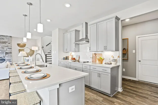 a kitchen with stainless steel appliances kitchen island a white table and chairs in it