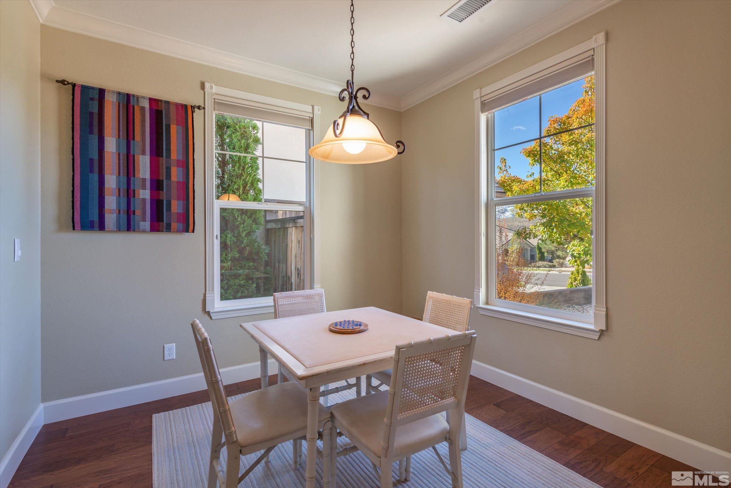 1340 Winterchase Way Reno, NV 89523 - Photo 17 of 40 a dining room with wooden floor a chandelier a wooden table and chairs