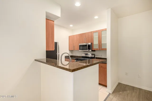 a kitchen with stainless steel appliances granite countertop a sink refrigerator and microwave