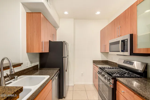 a kitchen with stainless steel appliances granite countertop a sink stove and refrigerator