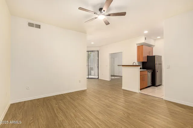 a view of empty room with wooden floor and window