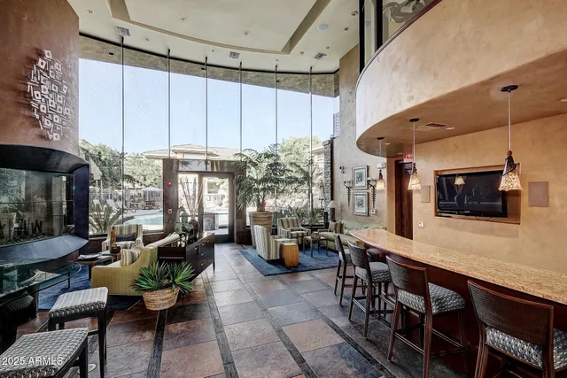 a living room with furniture a flat screen tv and a large window