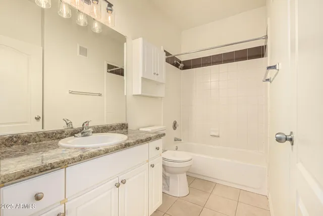 a bathroom with a granite countertop sink a toilet and shower