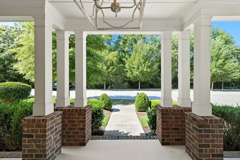 a living room with patio furniture and garden view