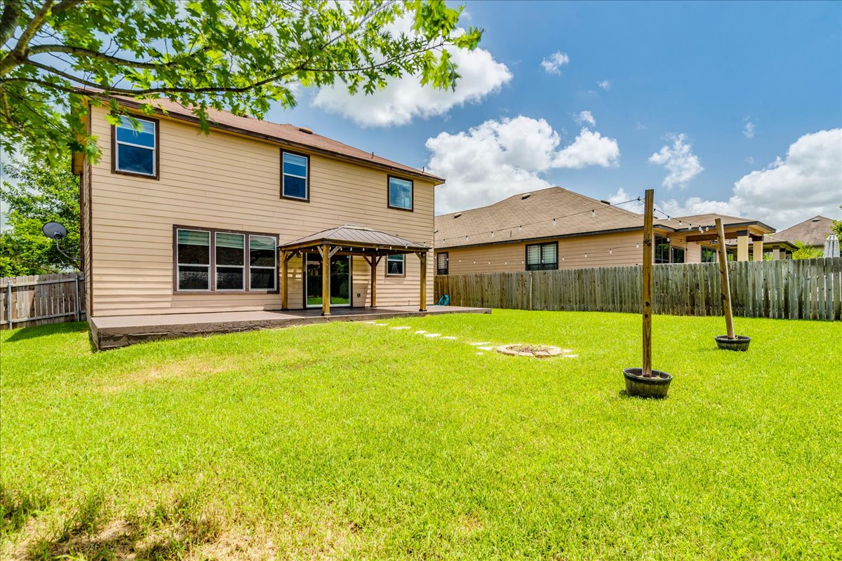 401 Waterleaf Boulevard Kyle, TX 78640 - Photo 27 of 28 Huge backyard with a patio the width of the home with a gazebo.