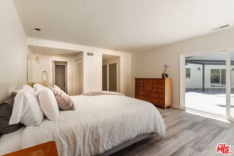 a bedroom with a bed and a large mirror