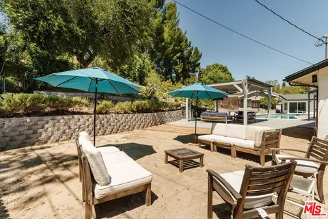 a view of a patio with chairs and a umbrella