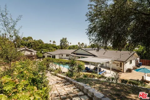 an aerial view of residential houses with yard and mountain view in back