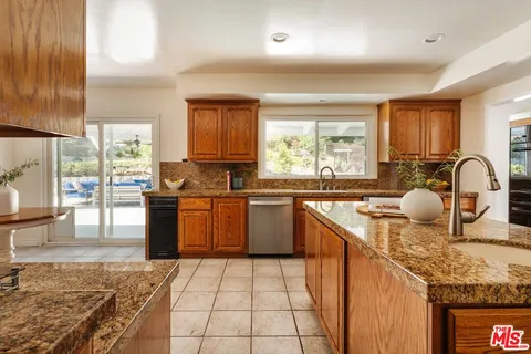 a kitchen with a sink a counter top space and stainless steel appliances