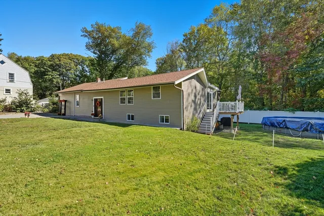 a view of a house with backyard and sitting area