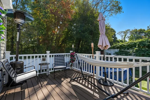 a view of a roof deck with table and chairs with wooden floor and fence