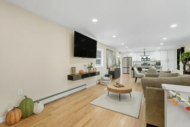 a living room with furniture a flat screen tv and kitchen view
