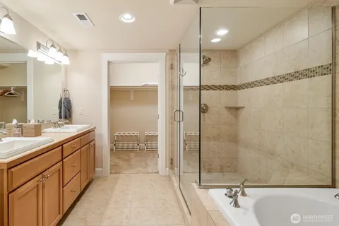a bathroom with a tub sink mirror and shower