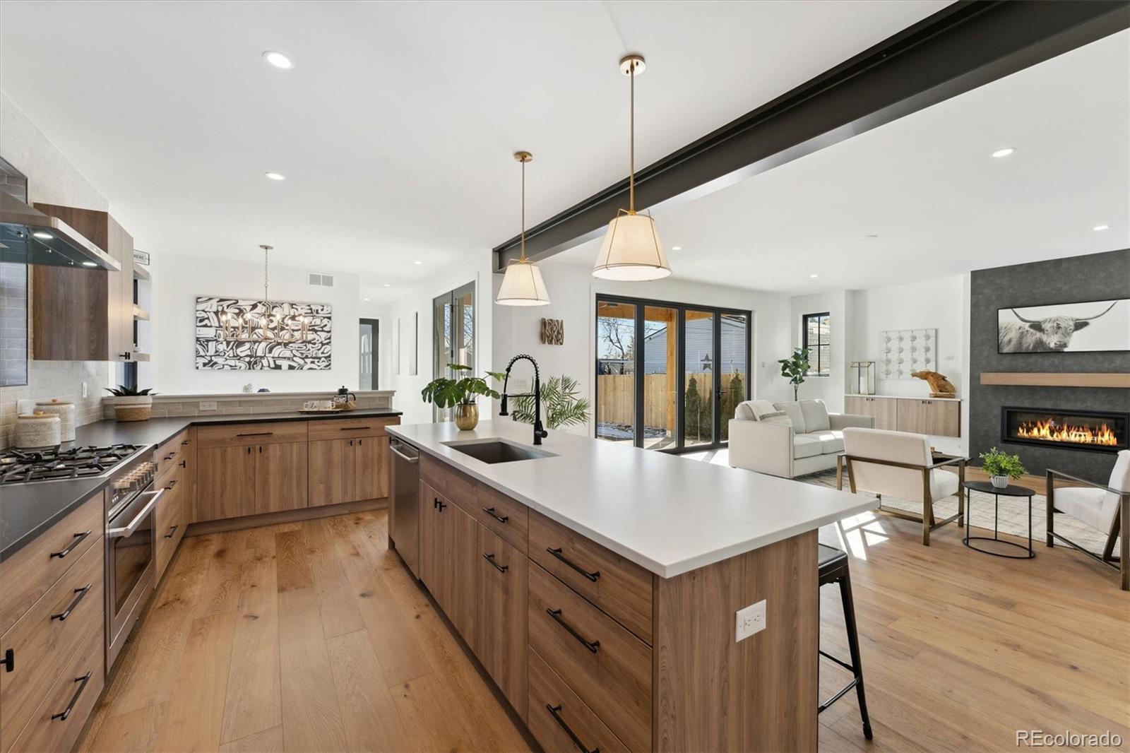 2540 Jay Street Edgewater, CO 80214 - Photo 11 of 37 a large kitchen with kitchen island a large counter space a sink appliances and cabinets