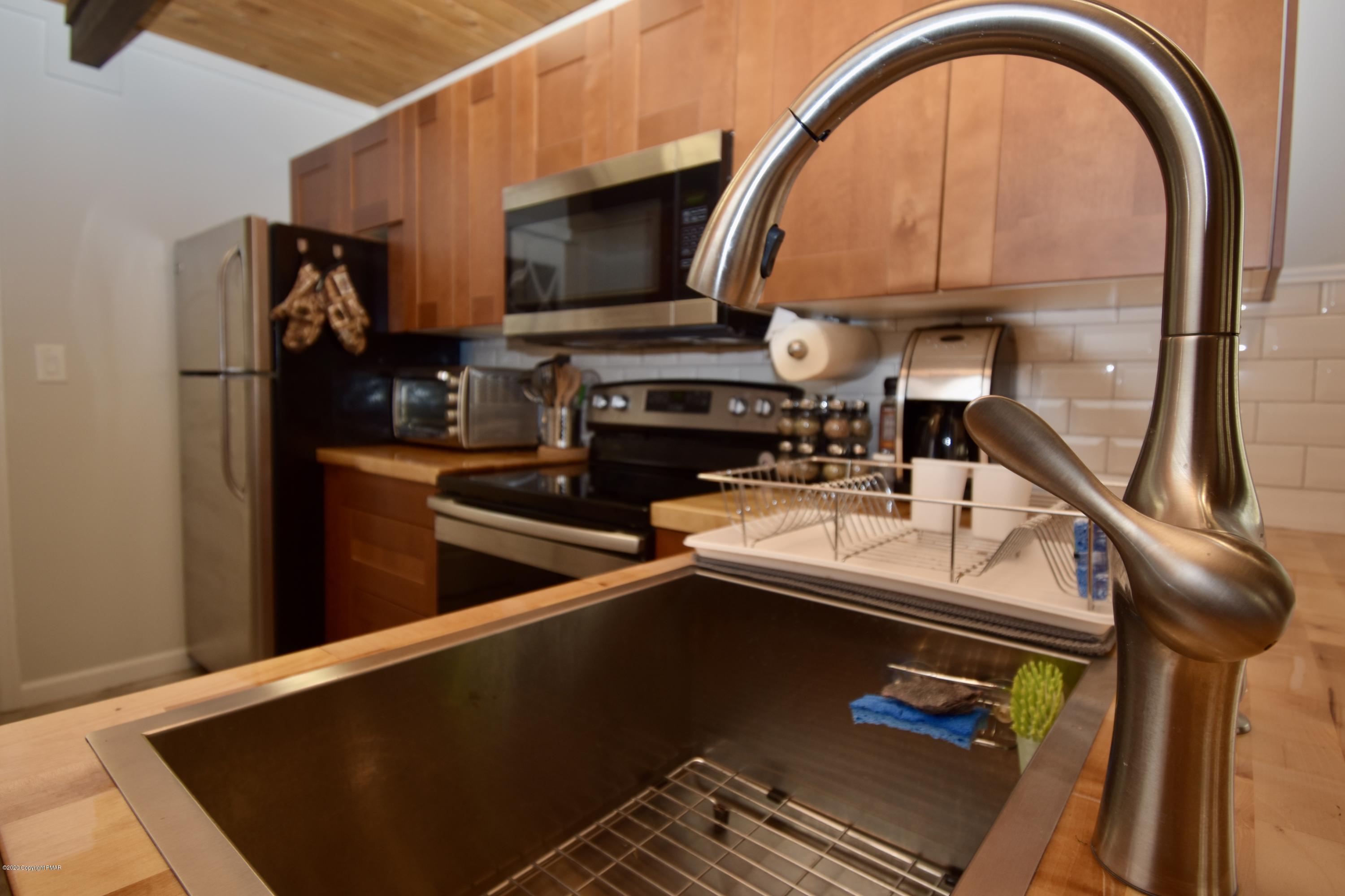 163 Canterbury Road Bushkill, PA 18324 - Photo 10 of 36 a kitchen with a sink a counter top space cabinets and a stove