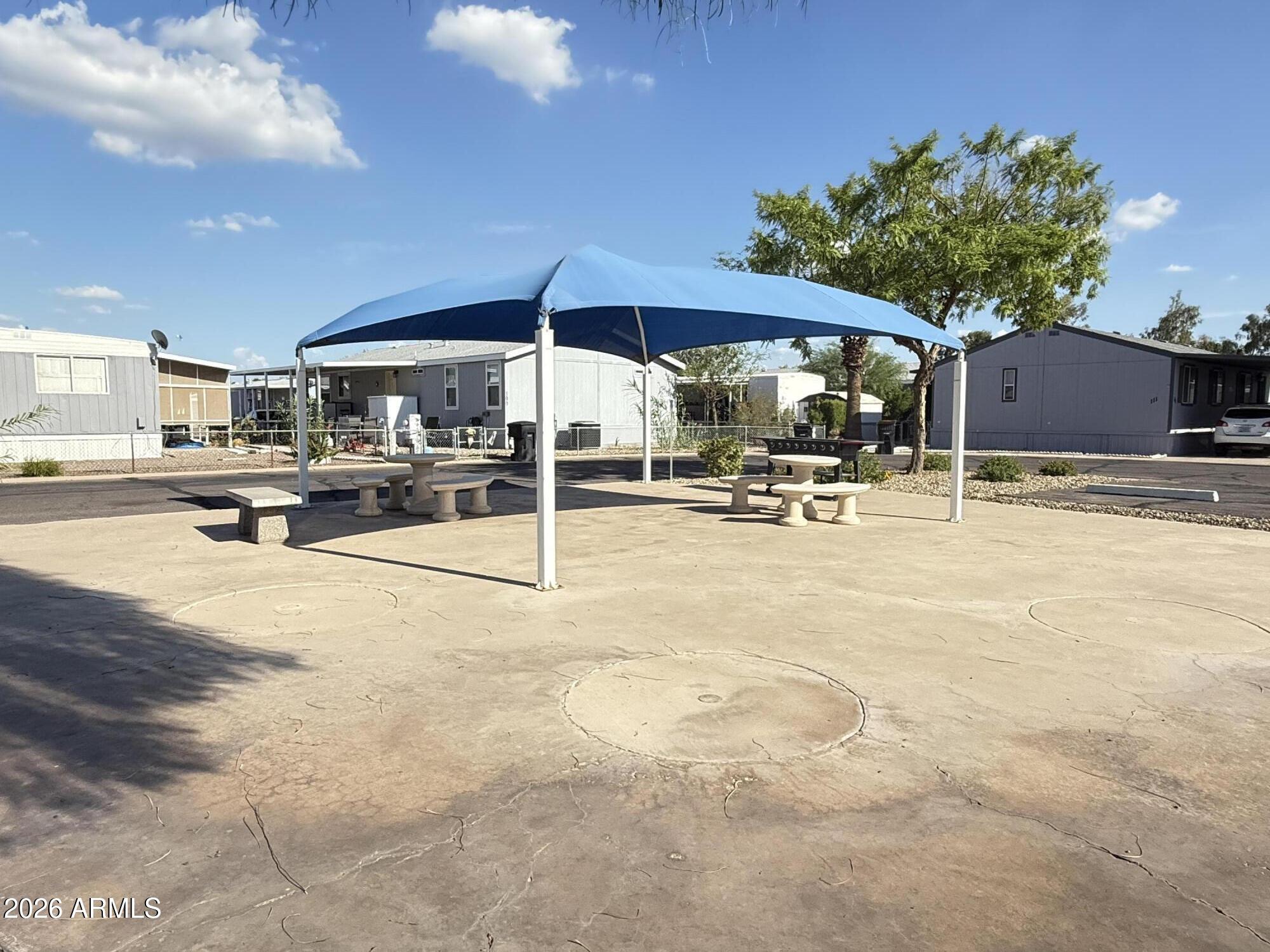 535 South Alma School Road, Unit 113 Mesa, AZ 85210 - Photo 36 of 41 a backyard of a house with table and chairs under an umbrella