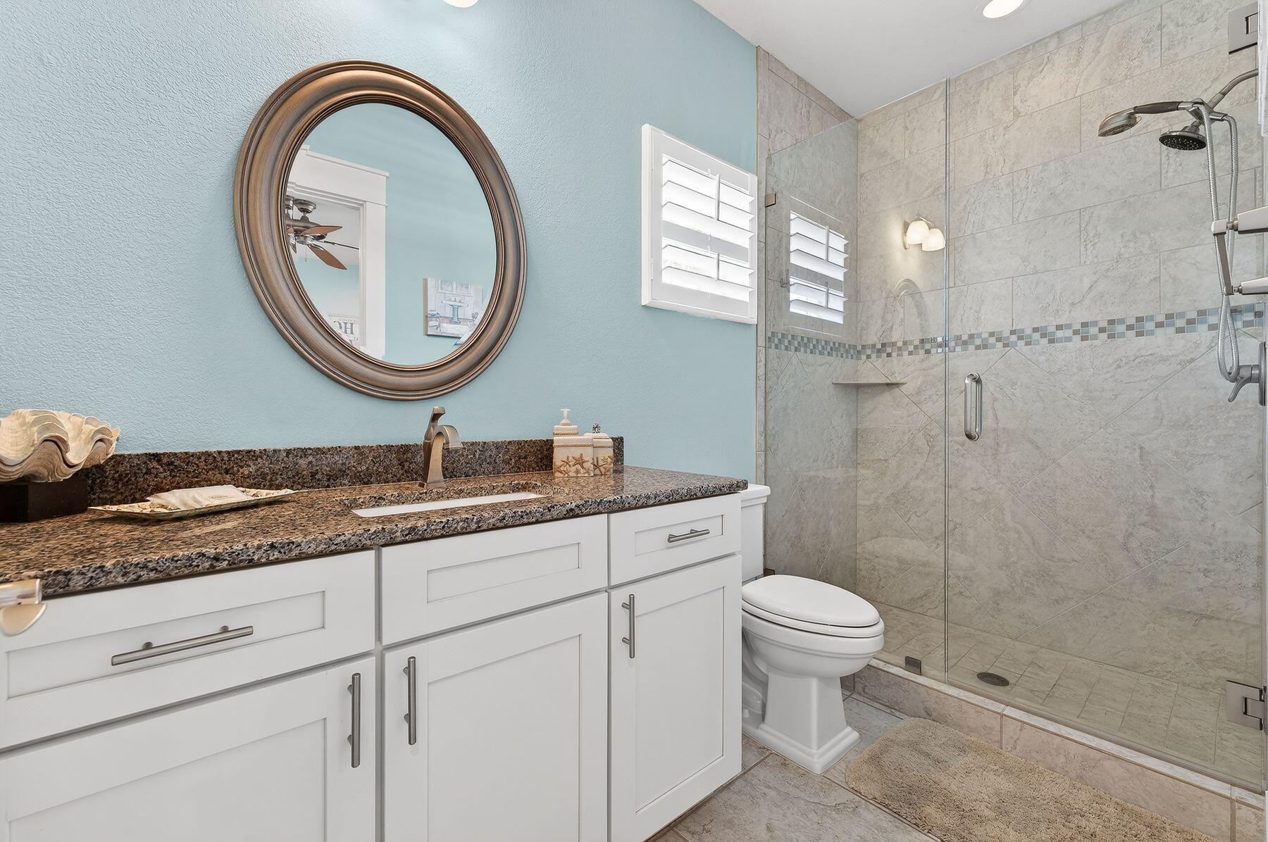 4480 Ocean View Drive Destin, FL 32541 - Photo 12 of 34 a bathroom with a granite countertop toilet a sink and a mirror