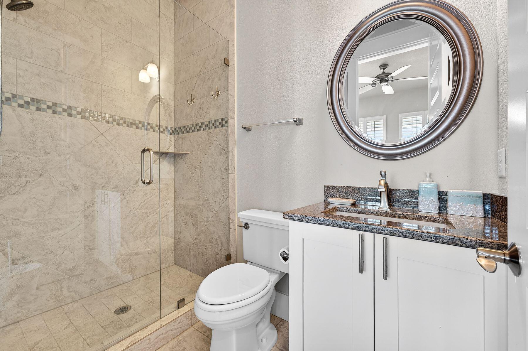4480 Ocean View Drive Destin, FL 32541 - Photo 17 of 34 a bathroom with a granite countertop toilet a sink and a mirror