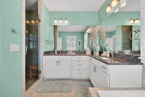 a spacious bathroom with a granite countertop sink a mirror and a vanity
