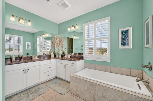 a bathroom with a bathtub sink and mirror