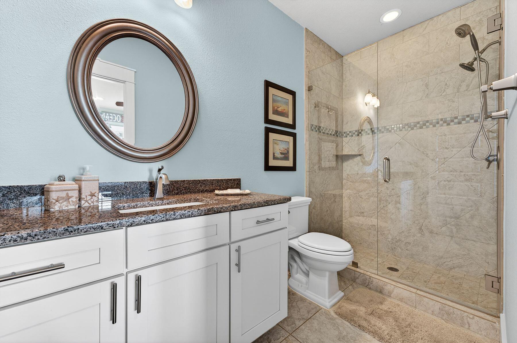 4480 Ocean View Drive Destin, FL 32541 - Photo 23 of 34 a bathroom with a granite countertop toilet a sink and a mirror