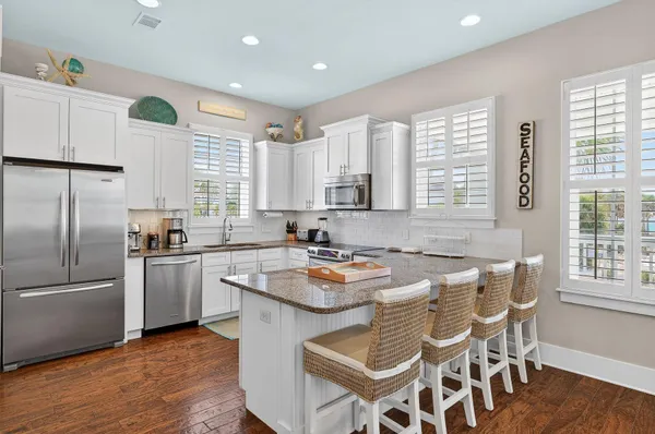 a kitchen with granite countertop stainless steel appliances a sink a counter space and a window