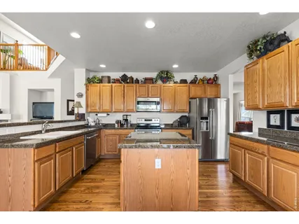 a kitchen with stainless steel appliances granite countertop a stove a sink dishwasher and a refrigerator