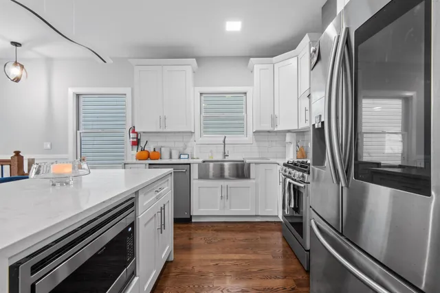 a kitchen with a sink appliances cabinets and a counter top space