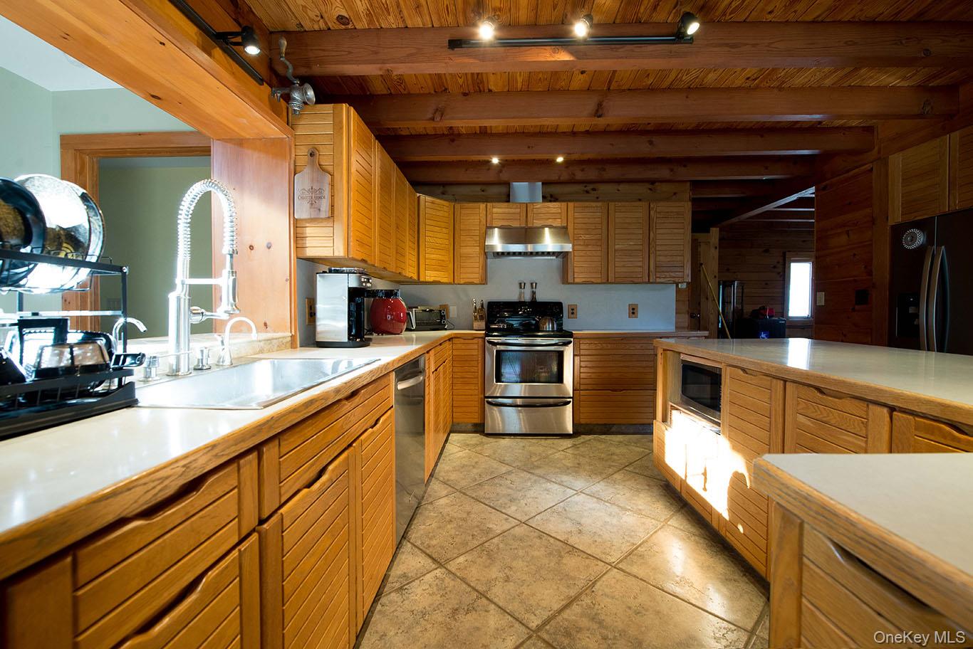 1644 Lakes Road Monroe, NY 10950 - Photo 15 of 49 a large kitchen with stainless steel appliances wooden cabinets and a stove