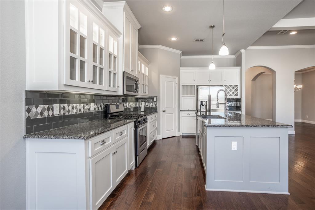 702 La Paloma Road Sanger, TX 76266 - Photo 12 of 40 a kitchen with granite countertop a stove and cabinets