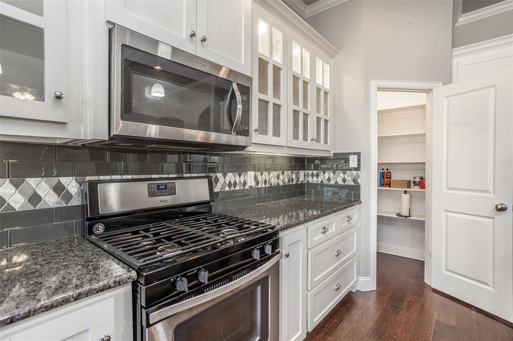 702 La Paloma Road Sanger, TX 76266 - Photo 16 of 40 a kitchen with stainless steel appliances granite countertop a stove and a microwave