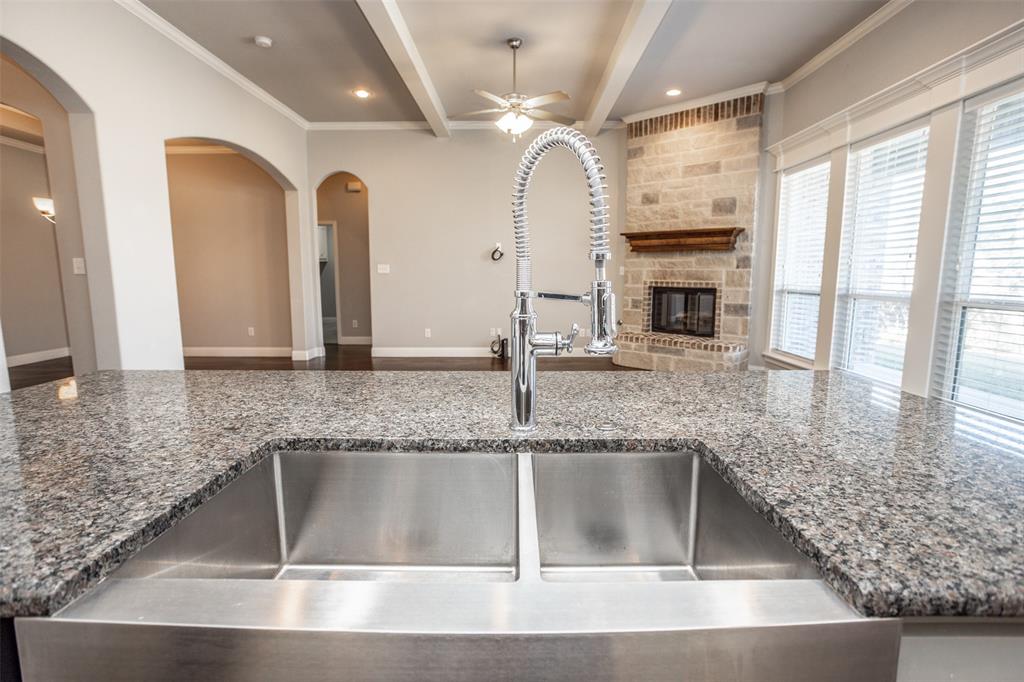 702 La Paloma Road Sanger, TX 76266 - Photo 40 of 40 a kitchen with granite countertop a sink a counter top space cabinets and stainless steel appliances