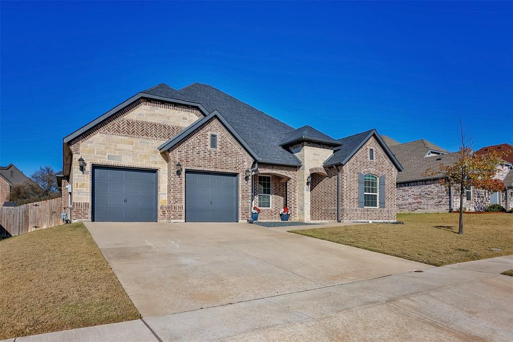702 La Paloma Road Sanger, TX 76266 - Photo 3 of 40 a front view of a house with a yard