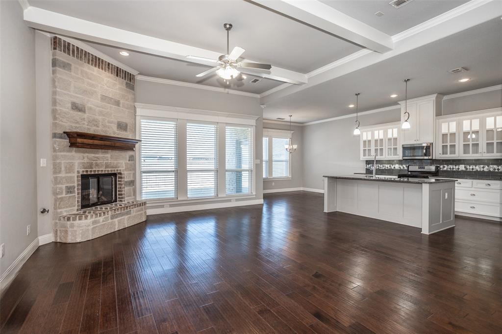 702 La Paloma Road Sanger, TX 76266 - Photo 7 of 40 a view of an empty room with wooden floor and a kitchen