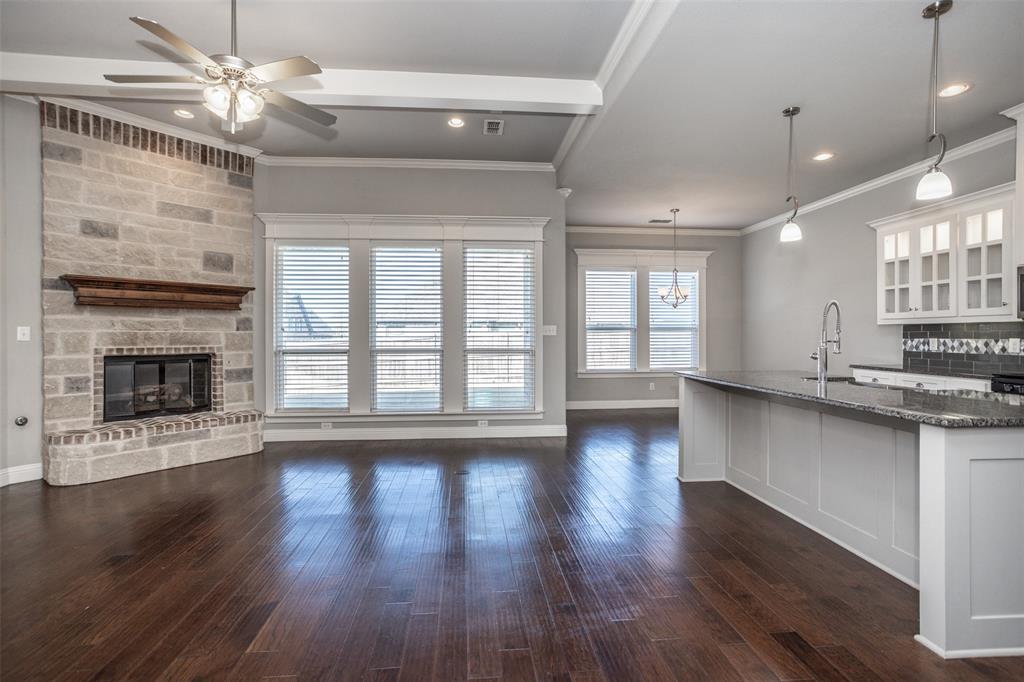 702 La Paloma Road Sanger, TX 76266 - Photo 8 of 40 a view of an empty room with wooden floor and a fireplace