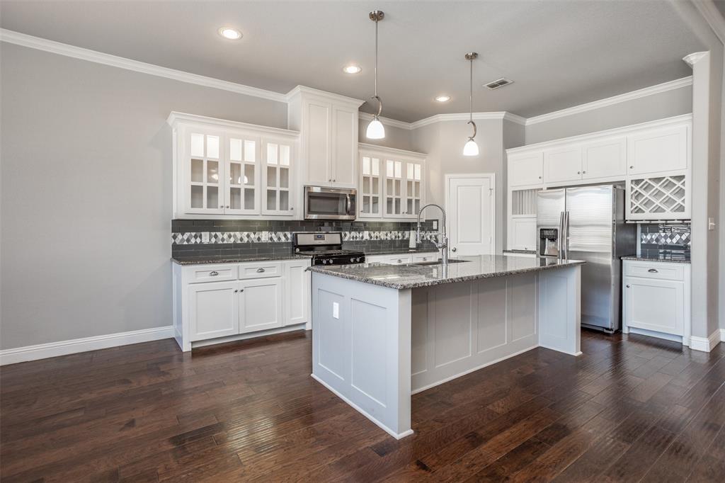 702 La Paloma Road Sanger, TX 76266 - Photo 10 of 40 a kitchen with stainless steel appliances granite countertop a stove a sink and a refrigerator