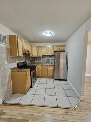 a kitchen with granite countertop a refrigerator and a stove top oven