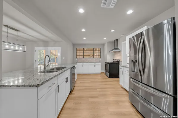 a kitchen with stainless steel appliances granite countertop a refrigerator and a sink